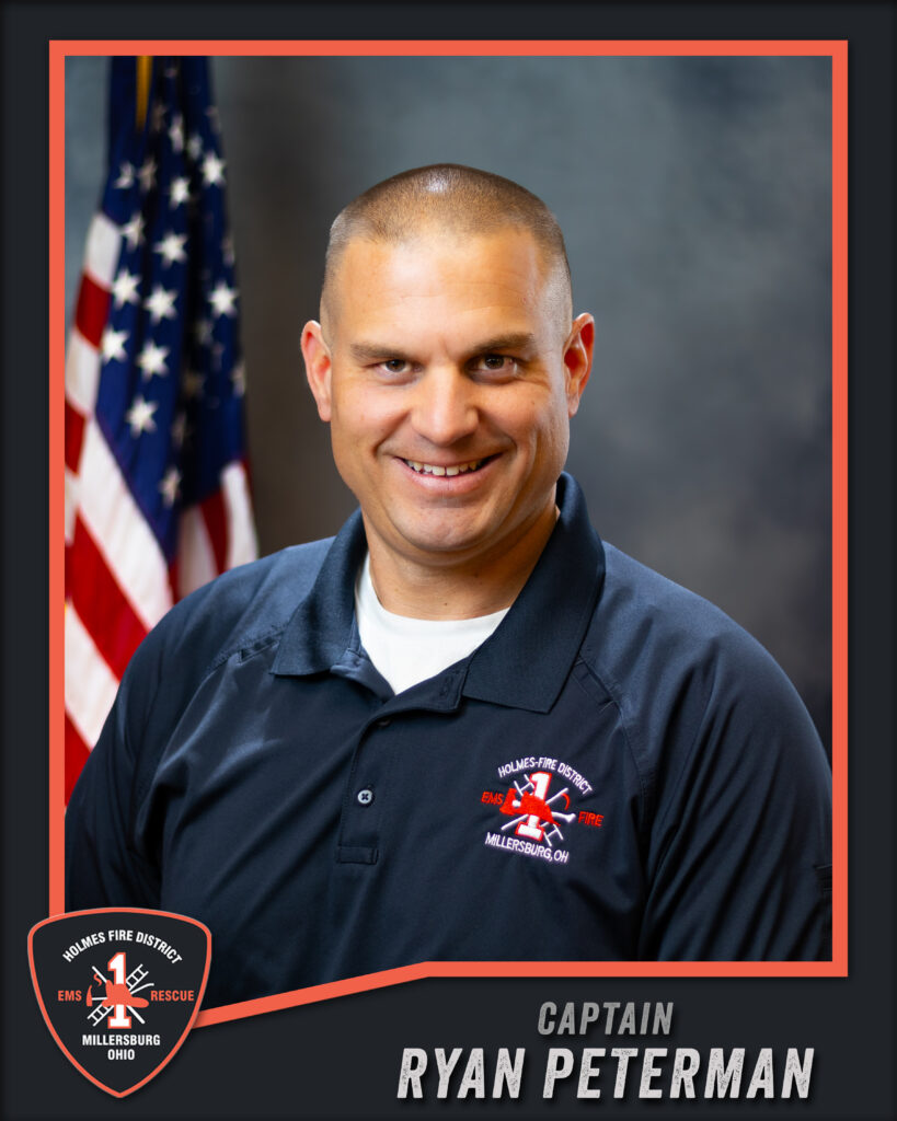 A man in a dark polo shirt with a fire department logo stands smiling in front of an American flag. The text reads: “Captain Ryan Peterman, Holmes Fire District, Millersburg, Ohio.”.