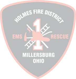 A black, red, and white shield-shaped emblem for Holmes Fire District 1 in Millersburg, Ohio. The emblem features crossed fire axes and ladders, with "EMS" and "Rescue" written on either side. The number "1" is centrally placed, and a firefighter helmet overlays it.